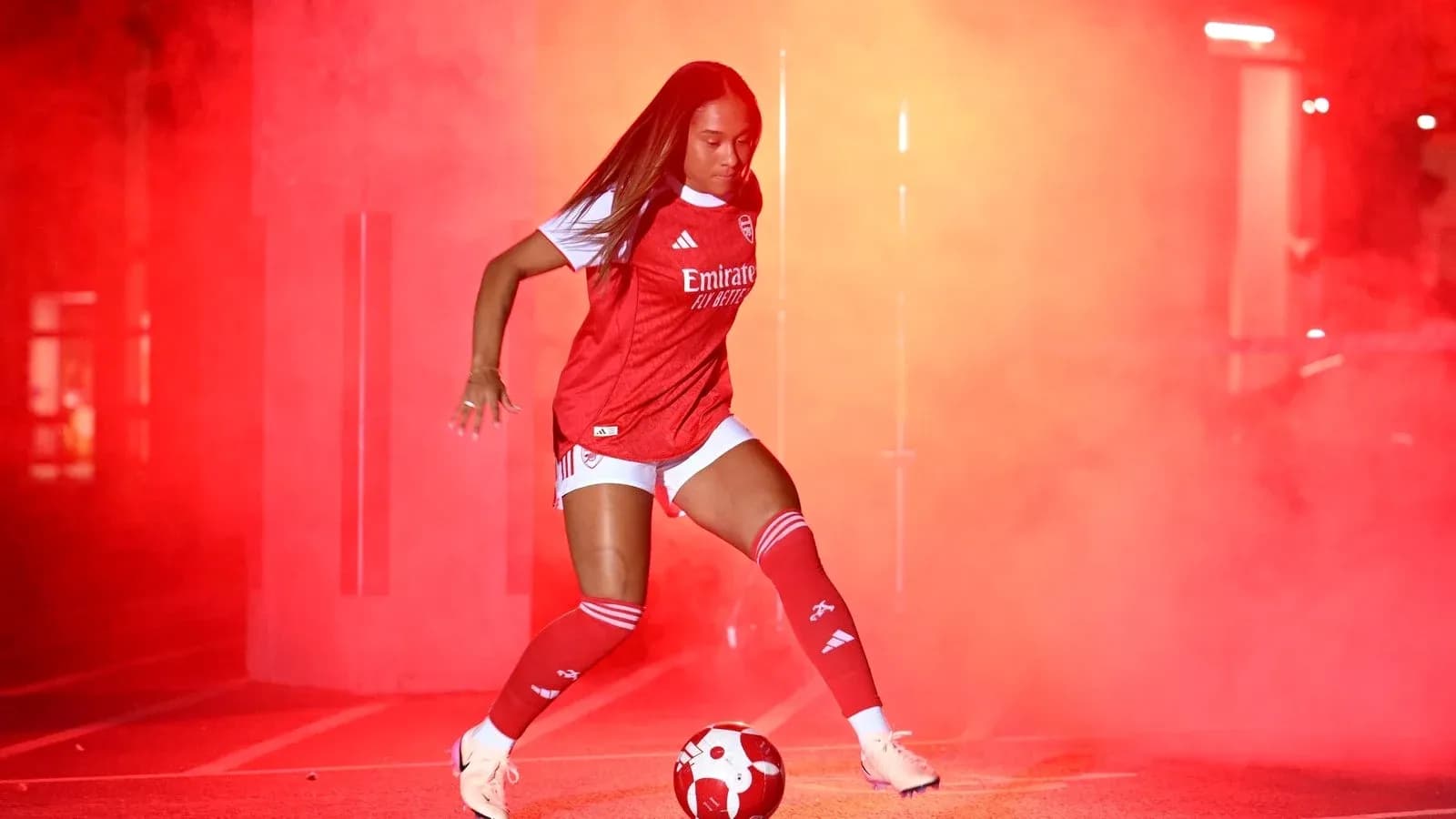 Jugadora de fútbol de Arsenal en ambiente de humo rojo Jugadora de fútbol de Arsenal en ambiente de humo rojo