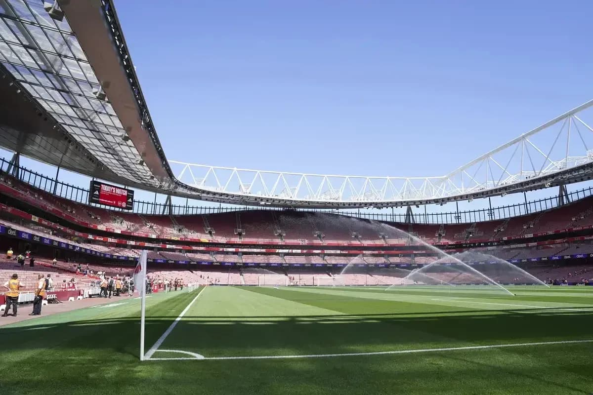 Estadio con césped regado y gradas vacías Estadio con césped regado y gradas vacías