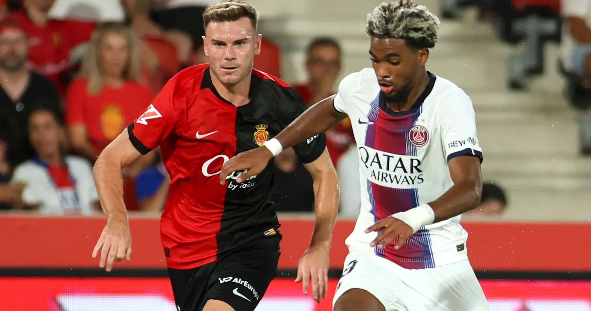 Jugadores de Mallorca y PSG compitiendo por el balón Jugadores de Mallorca y PSG compitiendo por el balón