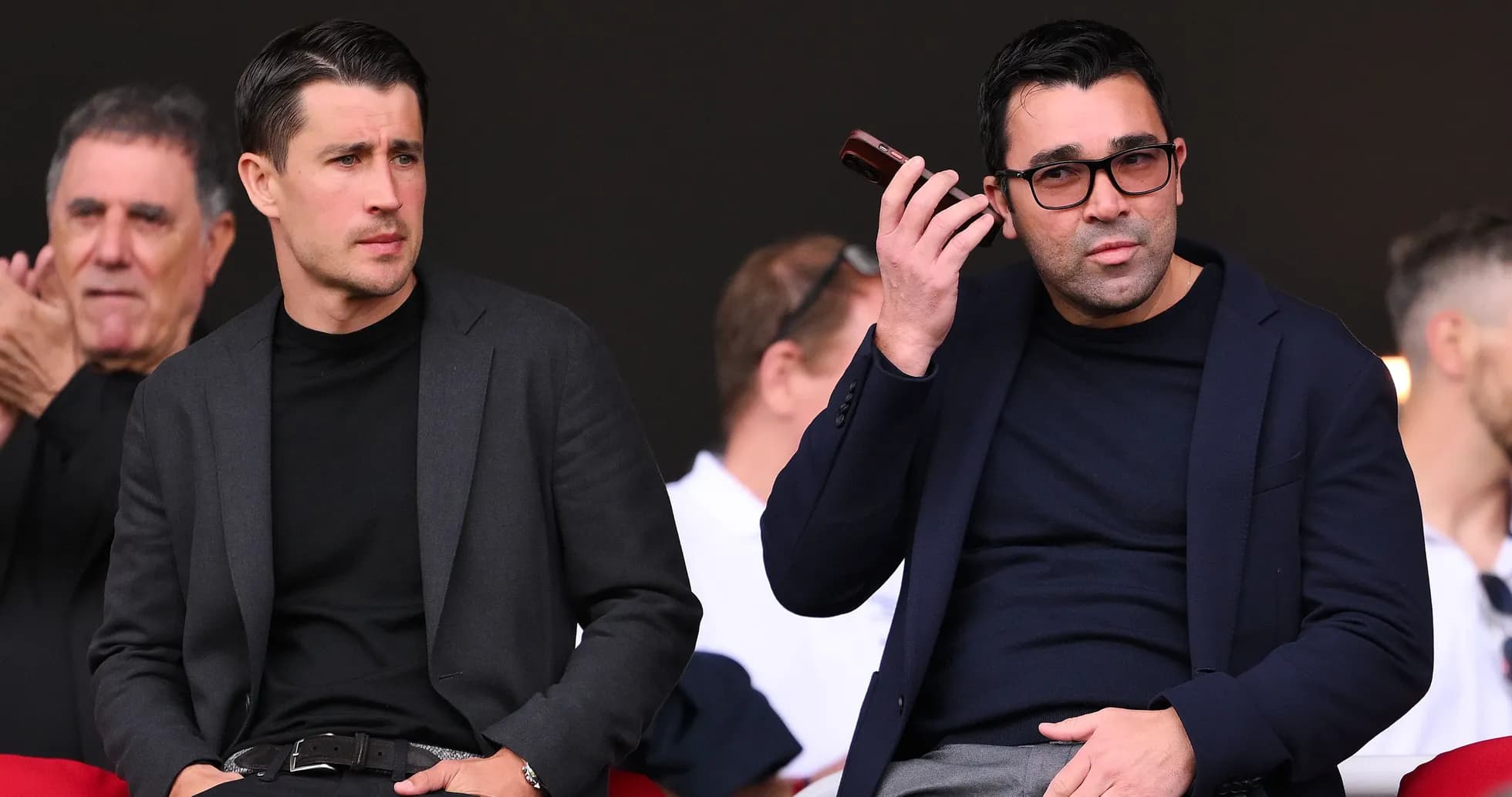 Dos hombres sentados en un evento deportivo Dos hombres sentados en un evento deportivo