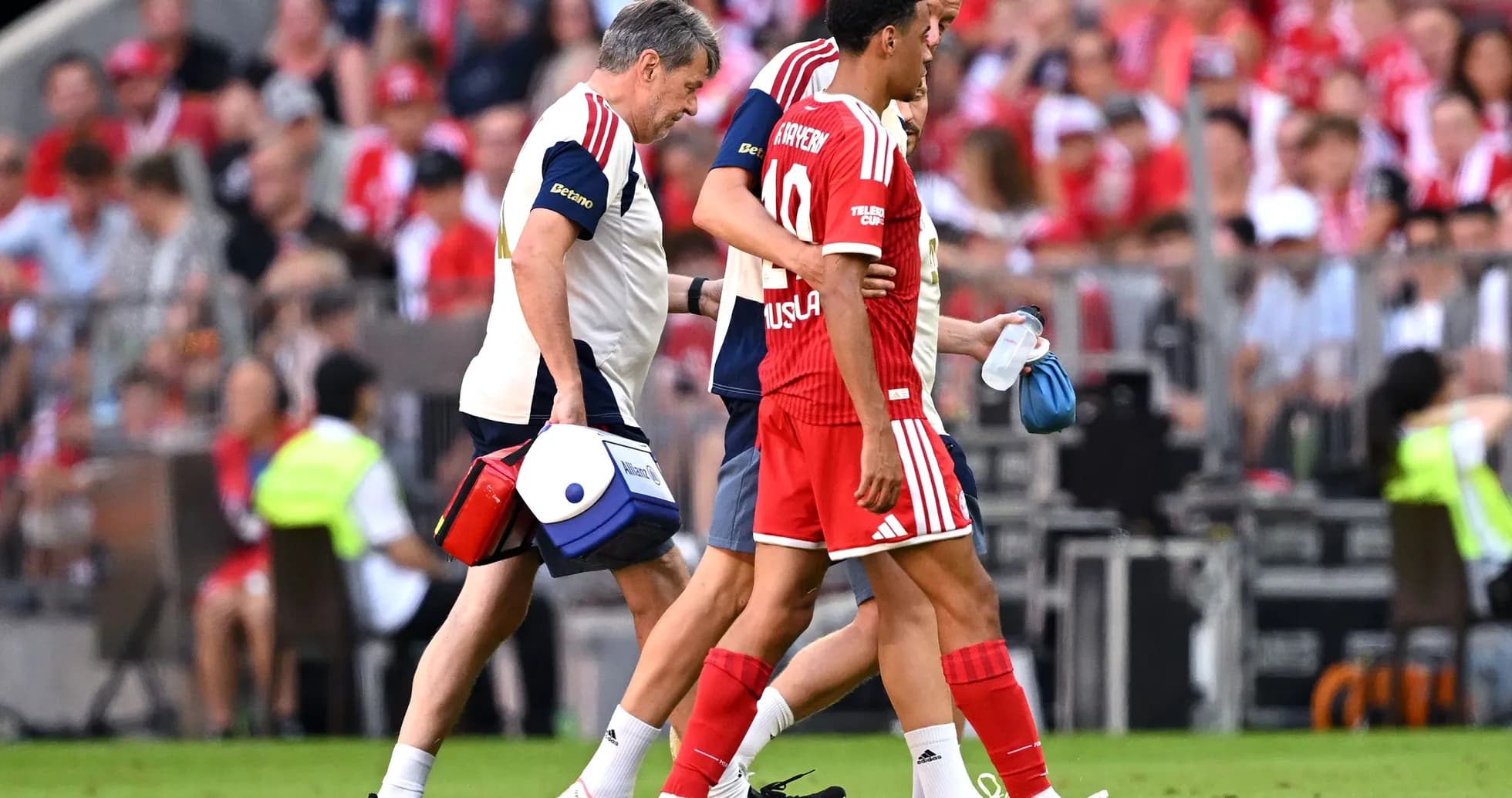 Jugador siendo ayudado por el personal médico en el campo Jugador siendo ayudado por el personal médico en el campo