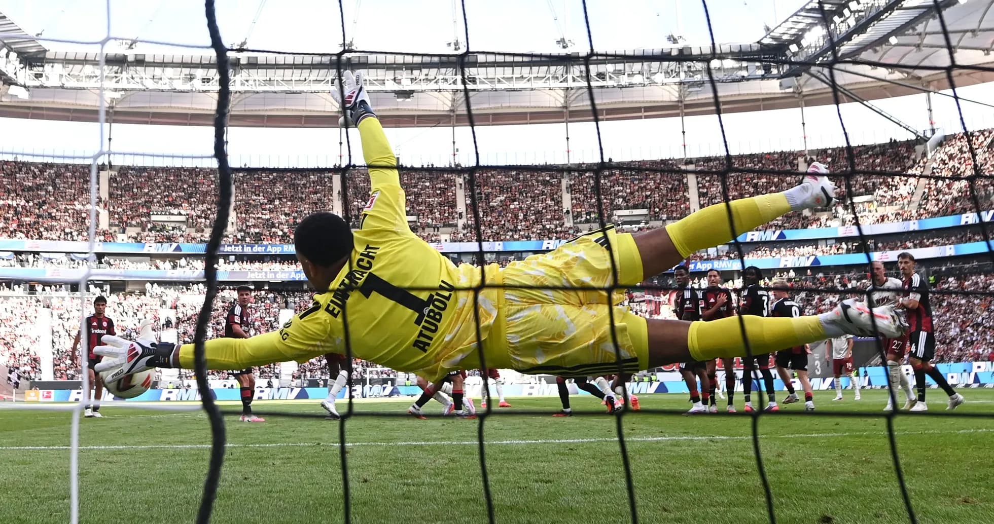 Portero saltando para detener un penalti en el estadio Portero saltando para detener un penalti en el estadio