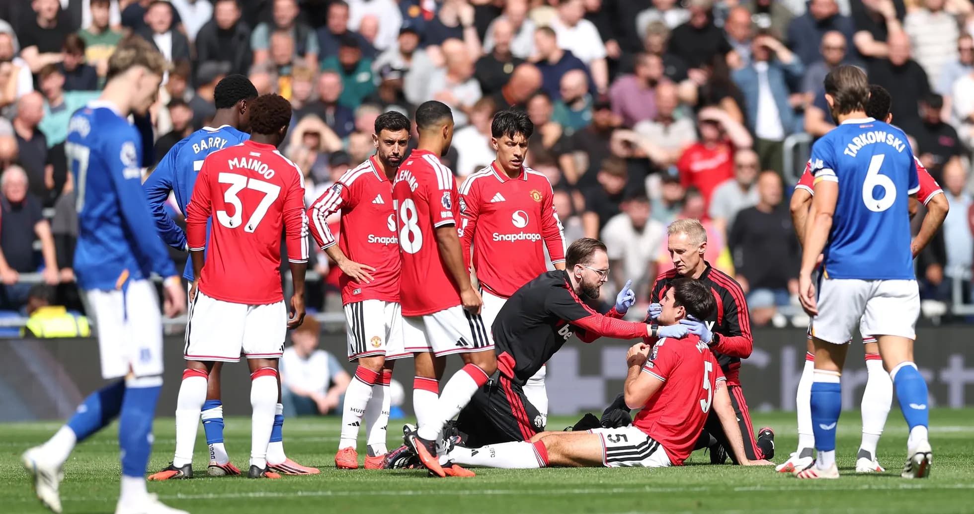 Jugadores de Manchester United rodeando a un compañero herido Jugadores de Manchester United rodeando a un compañero herido