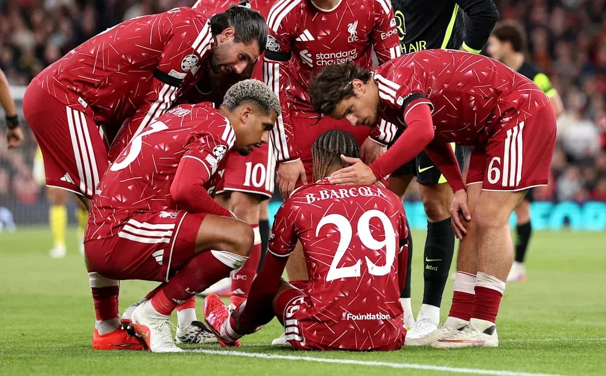 Jugadores de Liverpool rodeando a compañero caído Jugadores de Liverpool rodeando a compañero caído