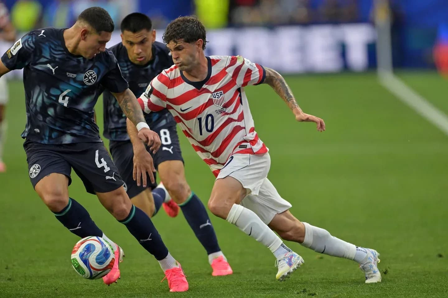 Christian Pulisic dribbling past Paraguayan defenders Christian Pulisic dribbling past Paraguayan defenders