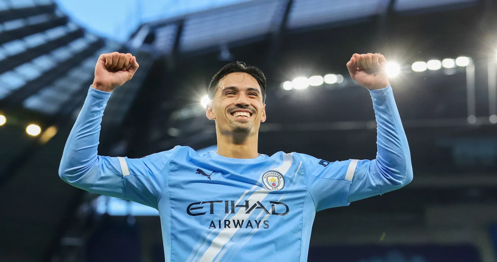 Jugador de Manchester City celebrando con los brazos levantados Jugador de Manchester City celebrando con los brazos levantados