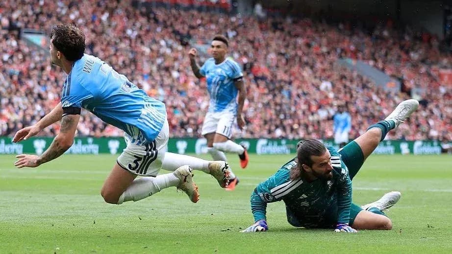 Jugador cayendo mientras el portero atrapa el balón Jugador cayendo mientras el portero atrapa el balón