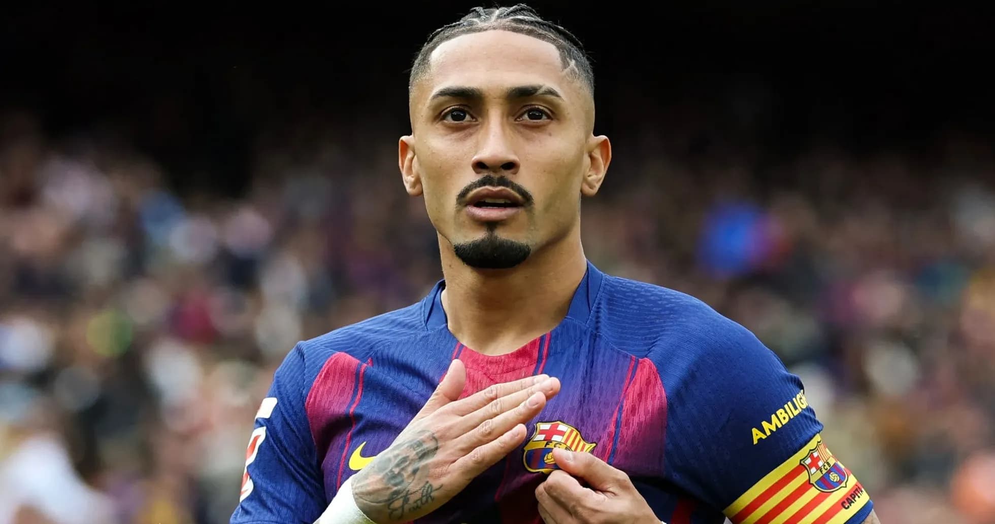 Jugador de FC Barcelona tocando el escudo del equipo Jugador de FC Barcelona tocando el escudo del equipo
