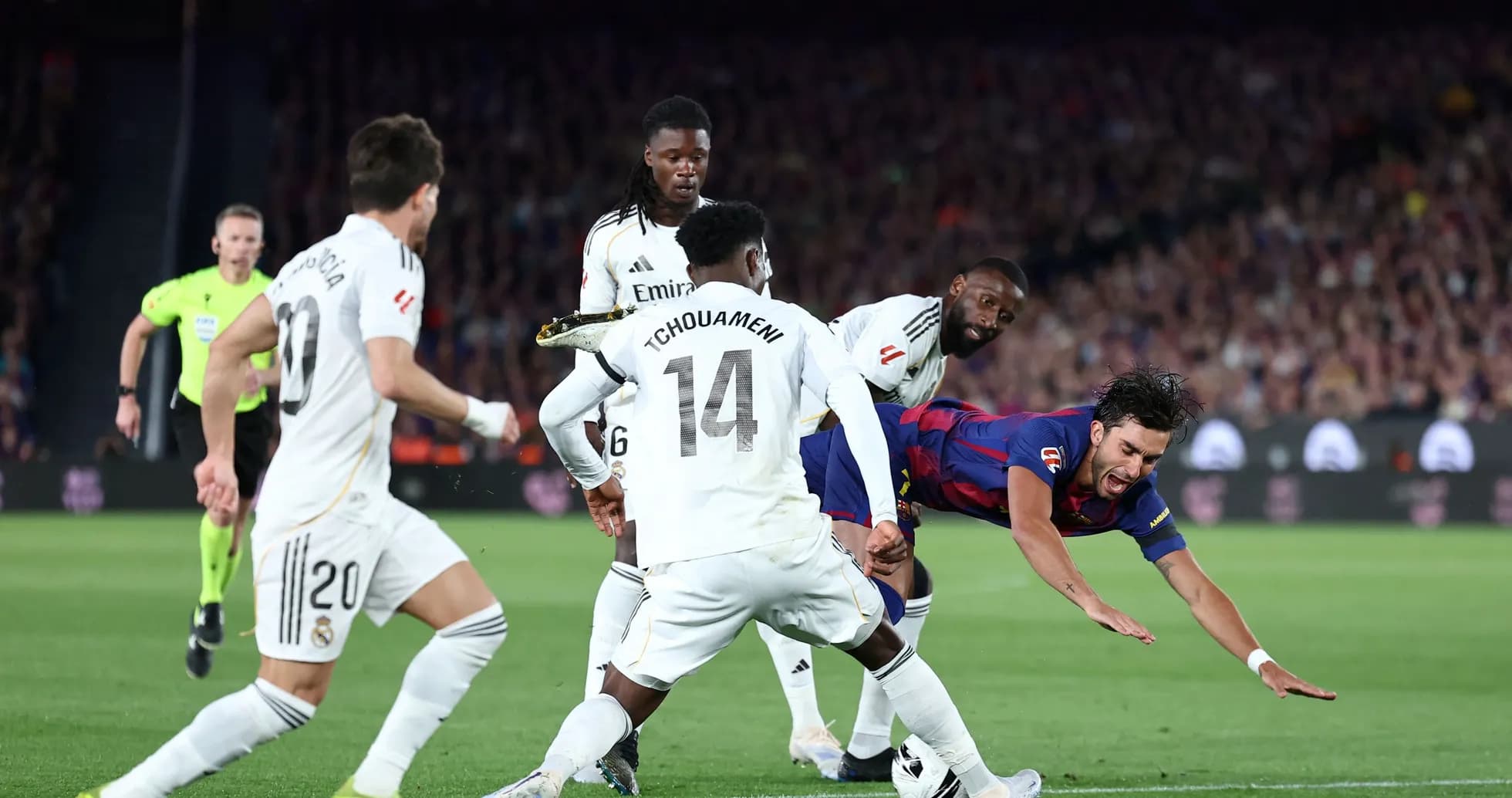 Jugador de Barcelona cayendo ante defensores del Real Madrid Jugador de Barcelona cayendo ante defensores del Real Madrid