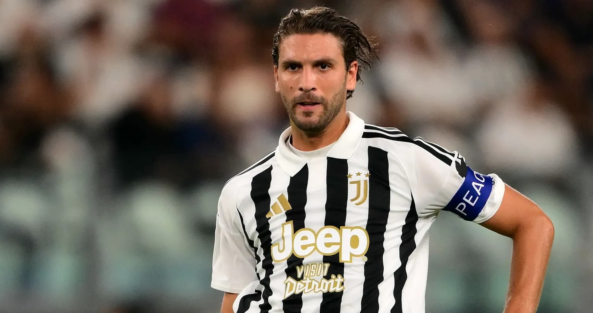 Jugador de Juventus con banda de capitán en el campo Jugador de Juventus con banda de capitán en el campo