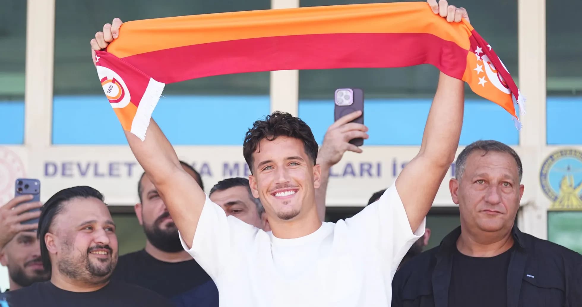 Jugador sosteniendo una bufanda de Galatasaray en presentación Jugador sosteniendo una bufanda de Galatasaray en presentación
