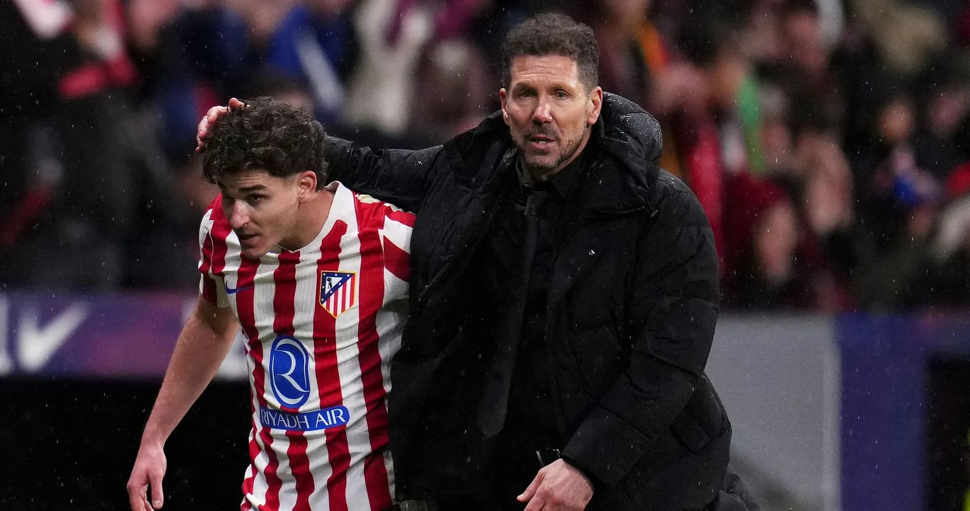 Entrenador ayudando a jugador de Atlético de Madrid Entrenador ayudando a jugador de Atlético de Madrid