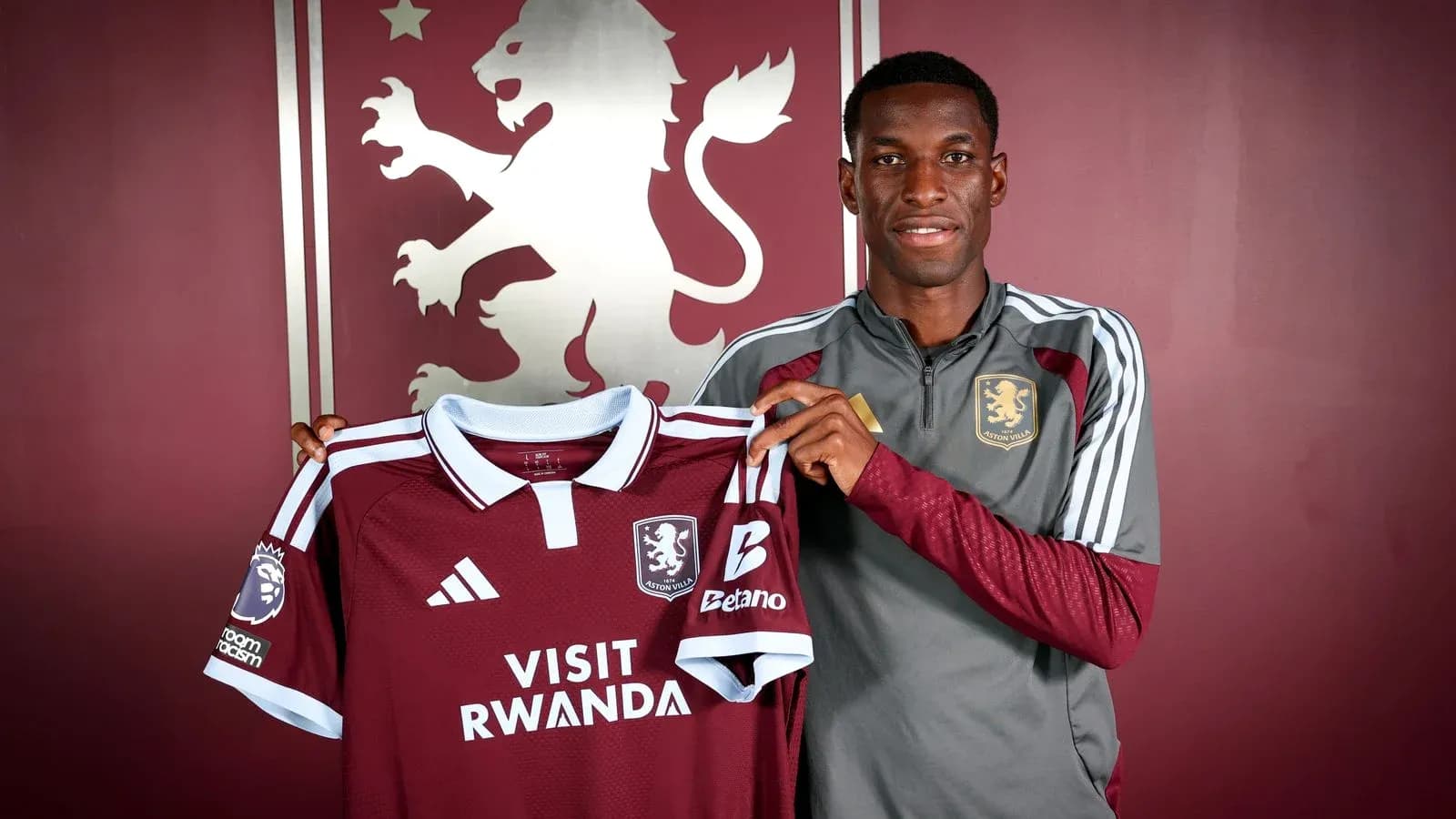 Jugador sosteniendo camiseta de Aston Villa en presentación Jugador sosteniendo camiseta de Aston Villa en presentación