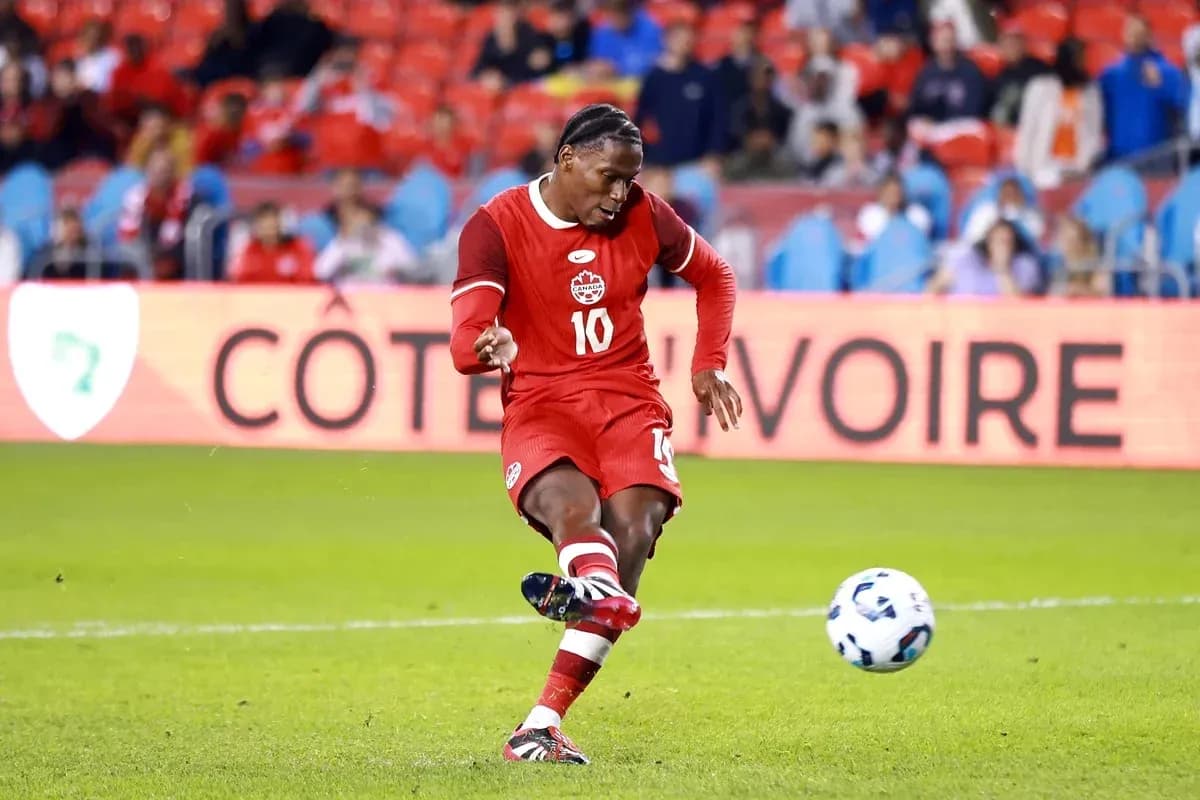 Jugador de Canadá pateando un balón en el campo Jugador de Canadá pateando un balón en el campo