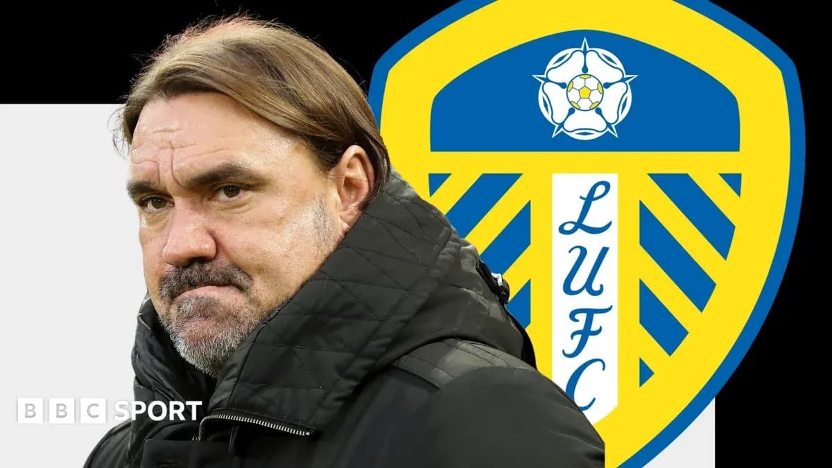Entrenador de pie frente al escudo de Leeds United Entrenador de pie frente al escudo de Leeds United