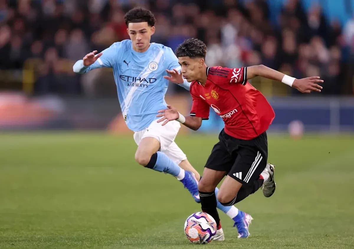 Jugador de Manchester United driblando a rival de Manchester City Jugador de Manchester United driblando a rival de Manchester City