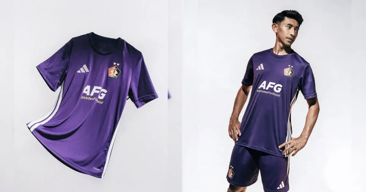 Jugador con uniforme morado de fútbol posando Jugador con uniforme morado de fútbol posando