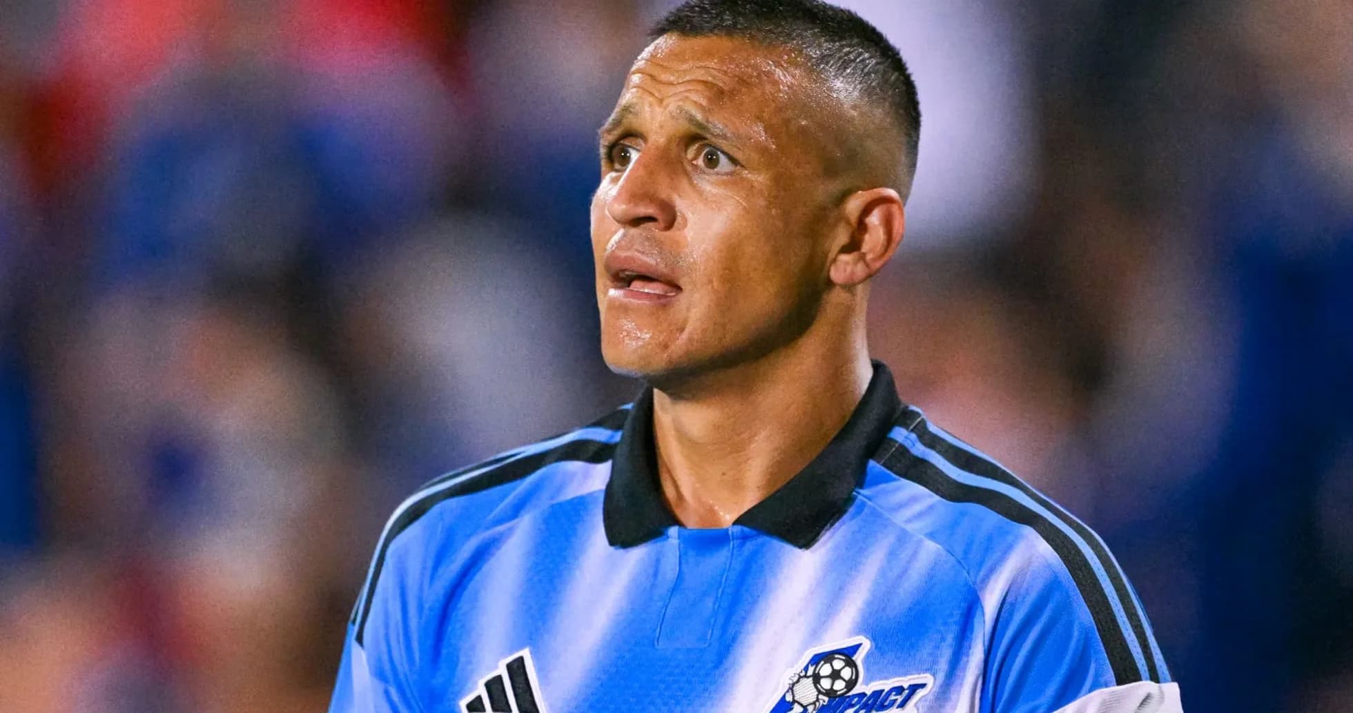 Jugador con uniforme azul mirando hacia el campo Jugador con uniforme azul mirando hacia el campo