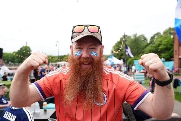A fan celebrating with Scottish flag face paint A fan celebrating with Scottish flag face paint