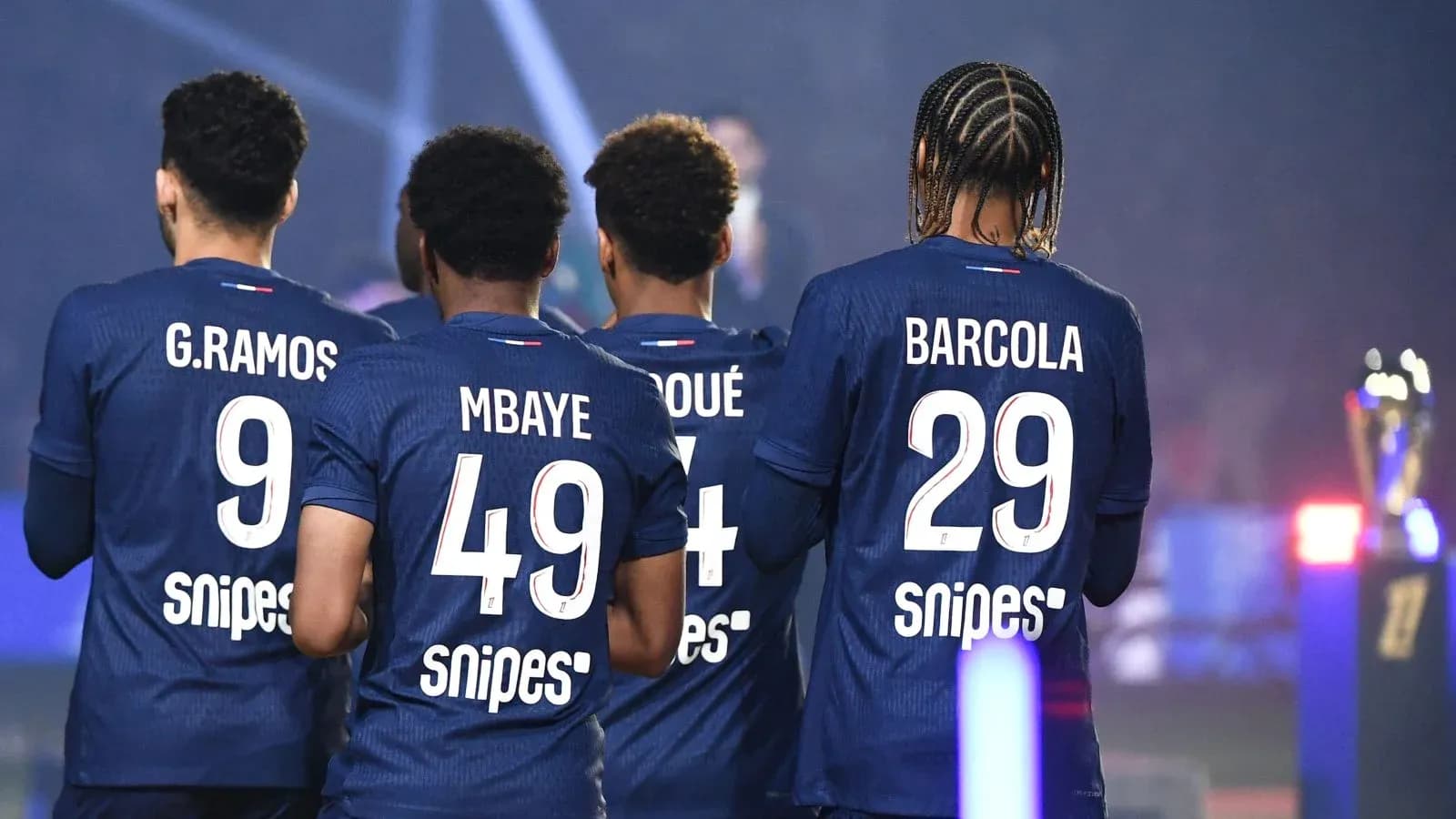 Jugadores de fútbol en uniforme de espaldas Jugadores de fútbol en uniforme de espaldas