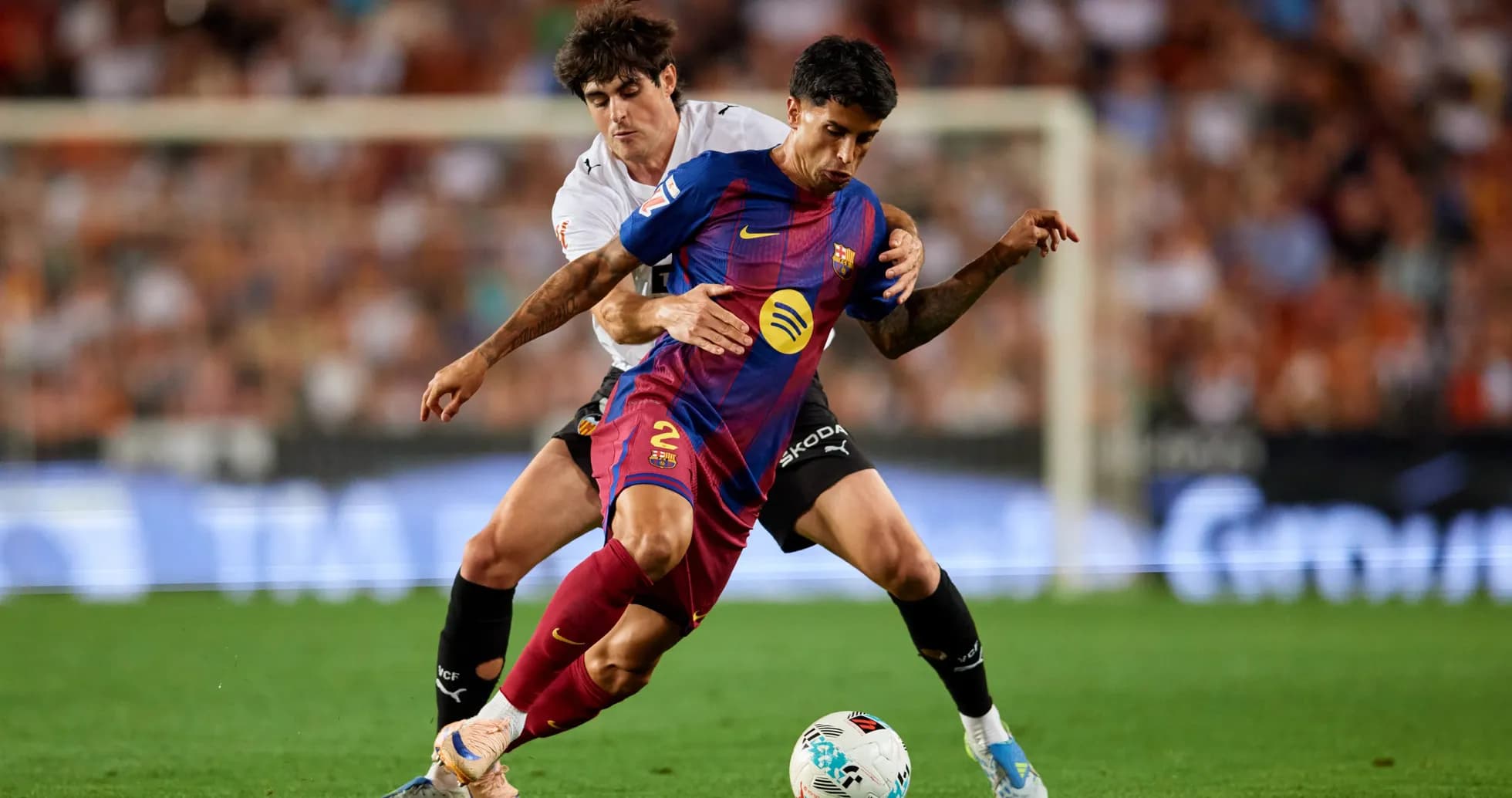 Jugador de Barcelona driblando mientras es marcado Jugador de Barcelona driblando mientras es marcado