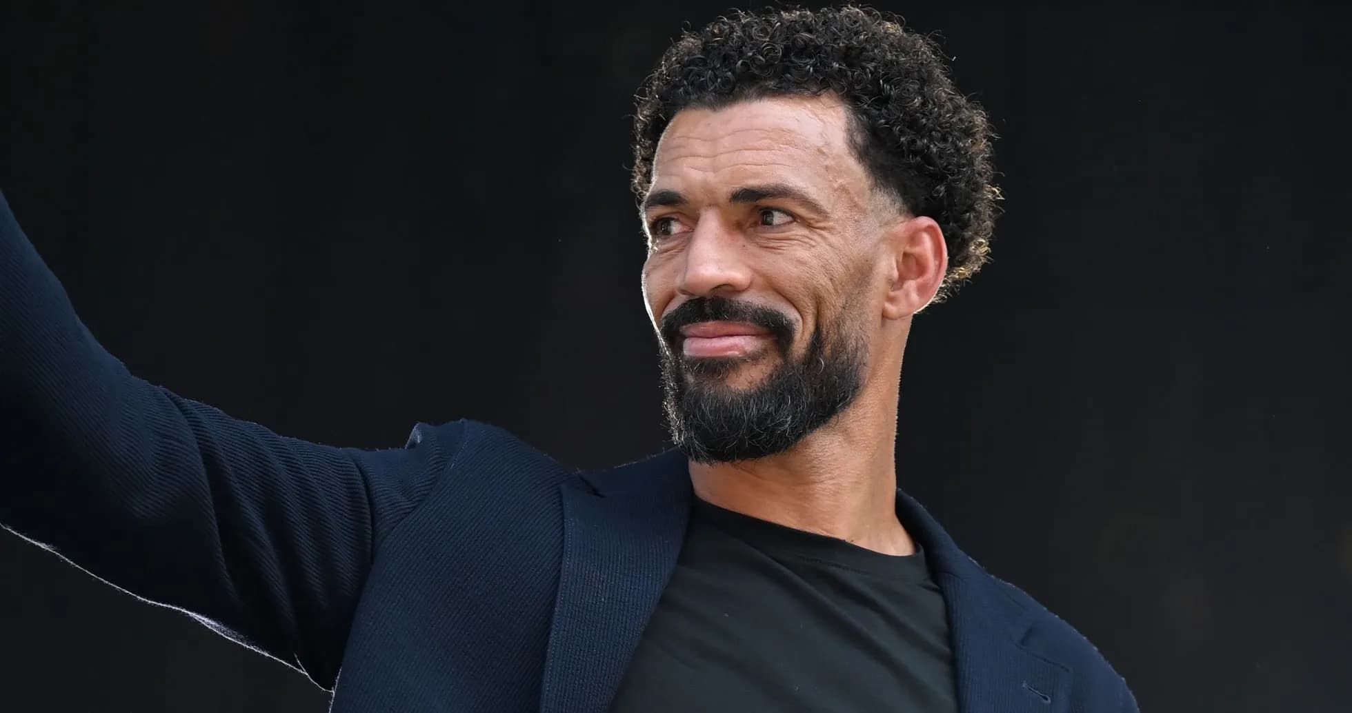 Hombre con barba saludando en un evento Hombre con barba saludando en un evento