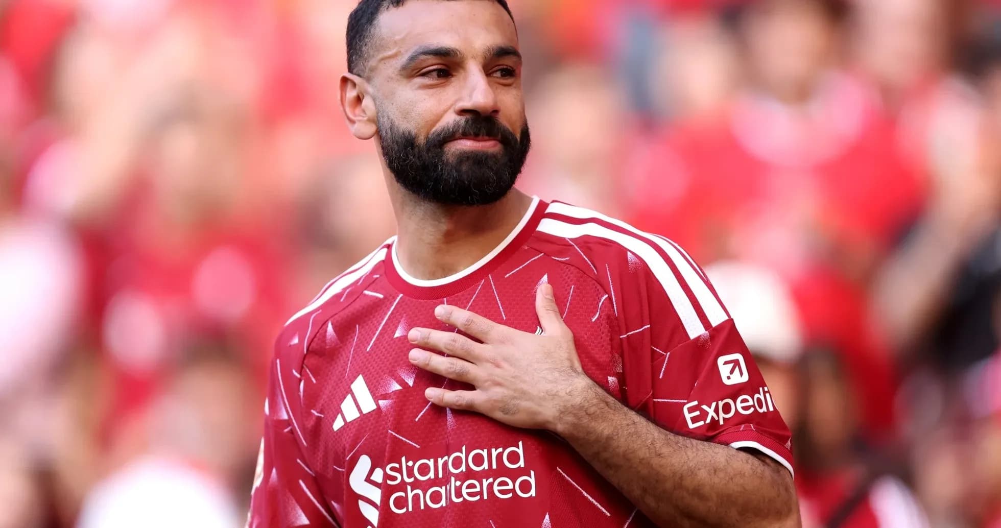 Jugador con camiseta roja saludando a la afición Jugador con camiseta roja saludando a la afición