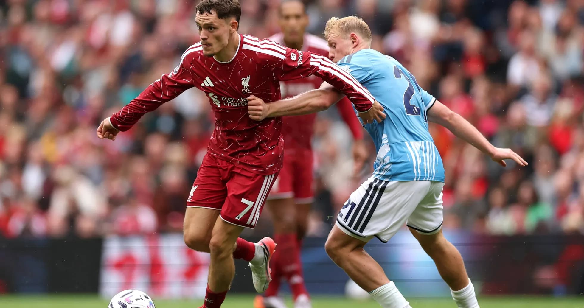 Jugador de Liverpool driblando a un oponente Jugador de Liverpool driblando a un oponente