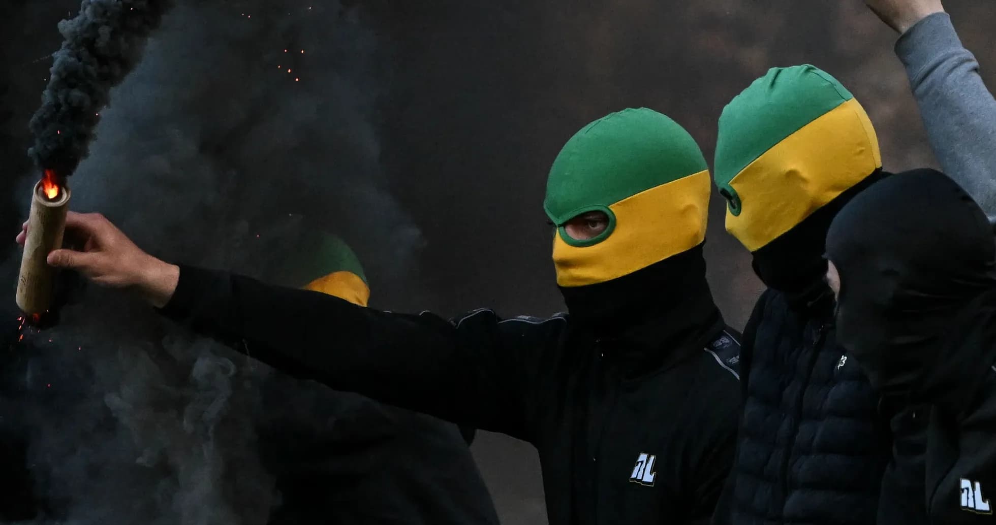Grupo de personas con máscaras encendiendo una bengala Grupo de personas con máscaras encendiendo una bengala
