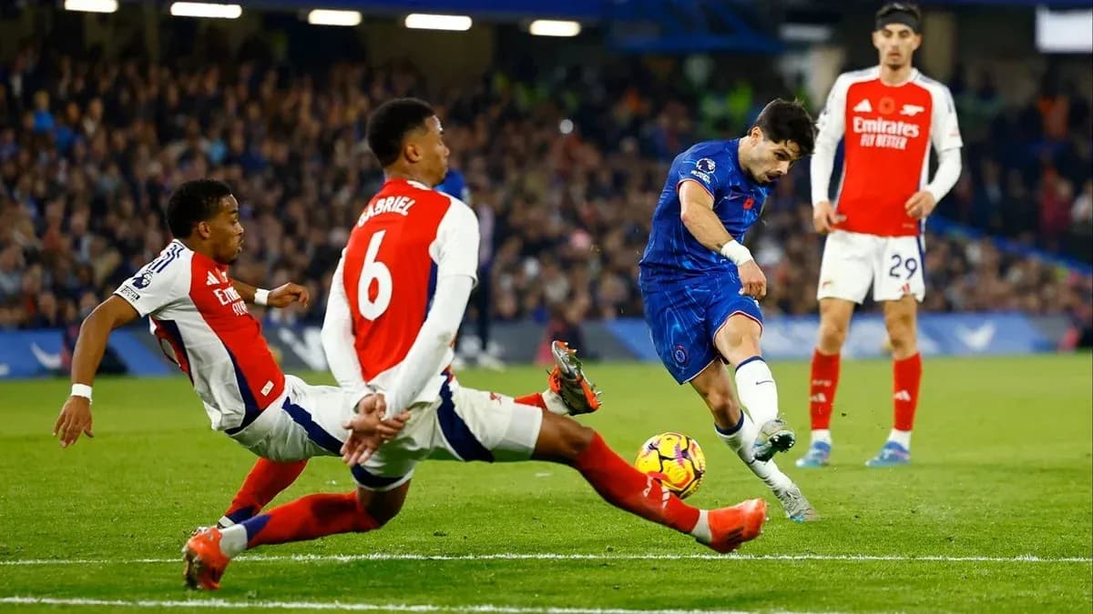 Jugador de Chelsea disparando entre defensores de Arsenal Jugador de Chelsea disparando entre defensores de Arsenal