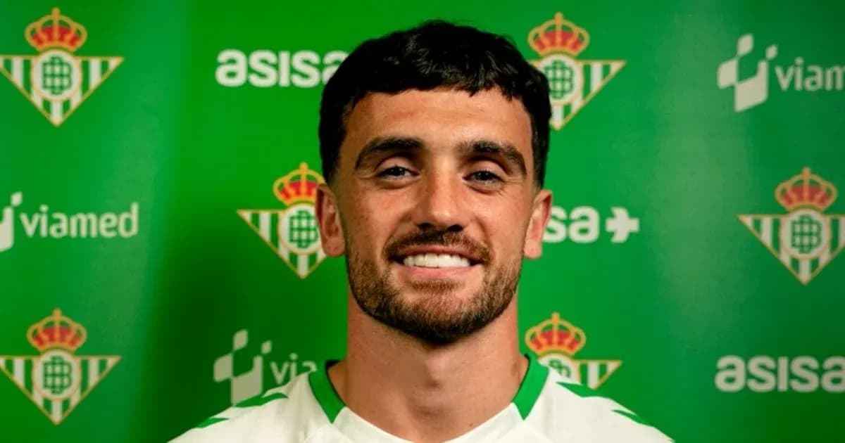Jugador sonriendo frente a fondo del Real Betis Jugador sonriendo frente a fondo del Real Betis