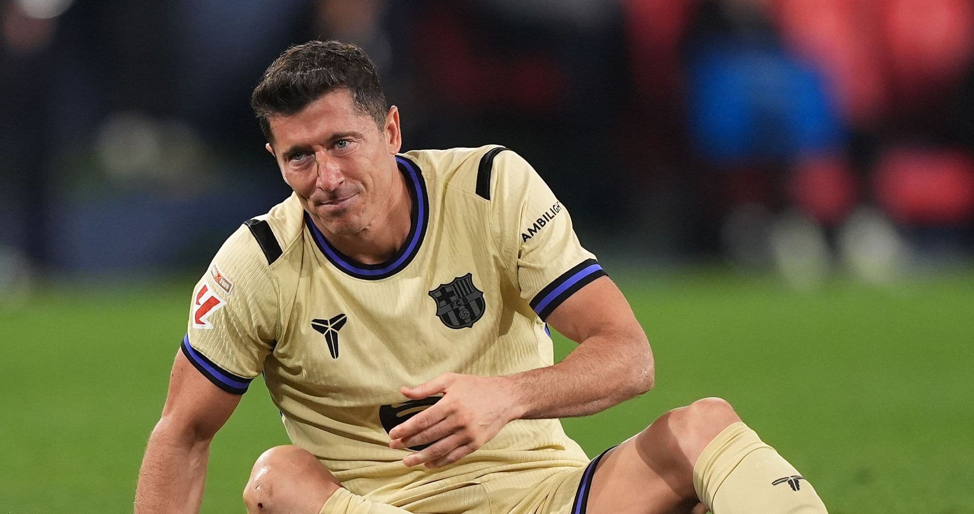 Jugador de Barcelona sentado en el campo tras partido Jugador de Barcelona sentado en el campo tras partido