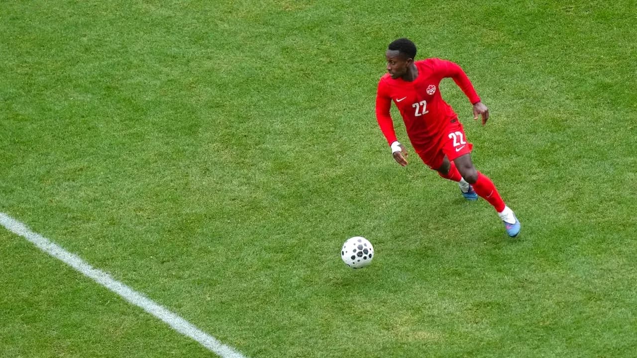 Jugador de Canadá corriendo tras el balón Jugador de Canadá corriendo tras el balón