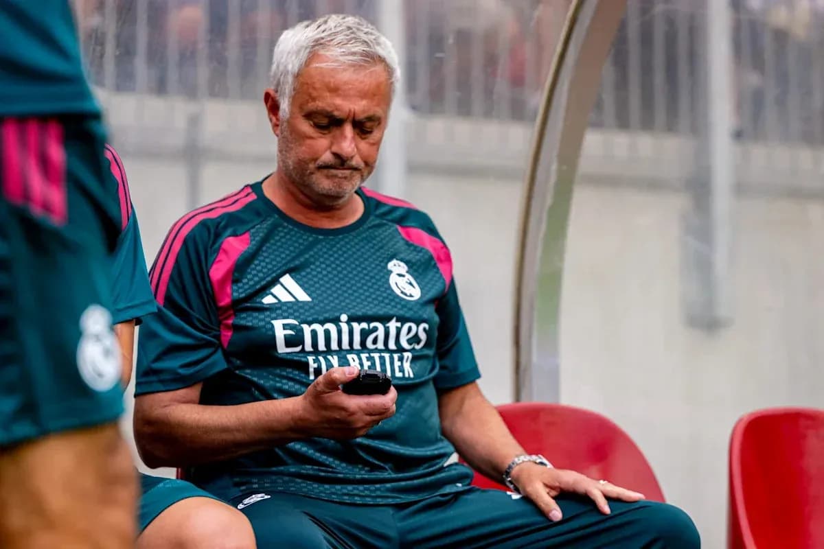 Entrenador sentado con teléfono en el banquillo Entrenador sentado con teléfono en el banquillo