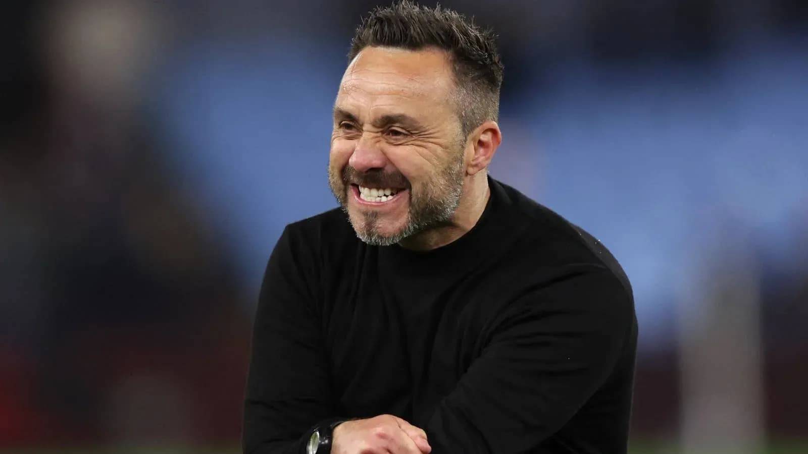 Entrenador sonriendo en el campo durante el partido Entrenador sonriendo en el campo durante el partido