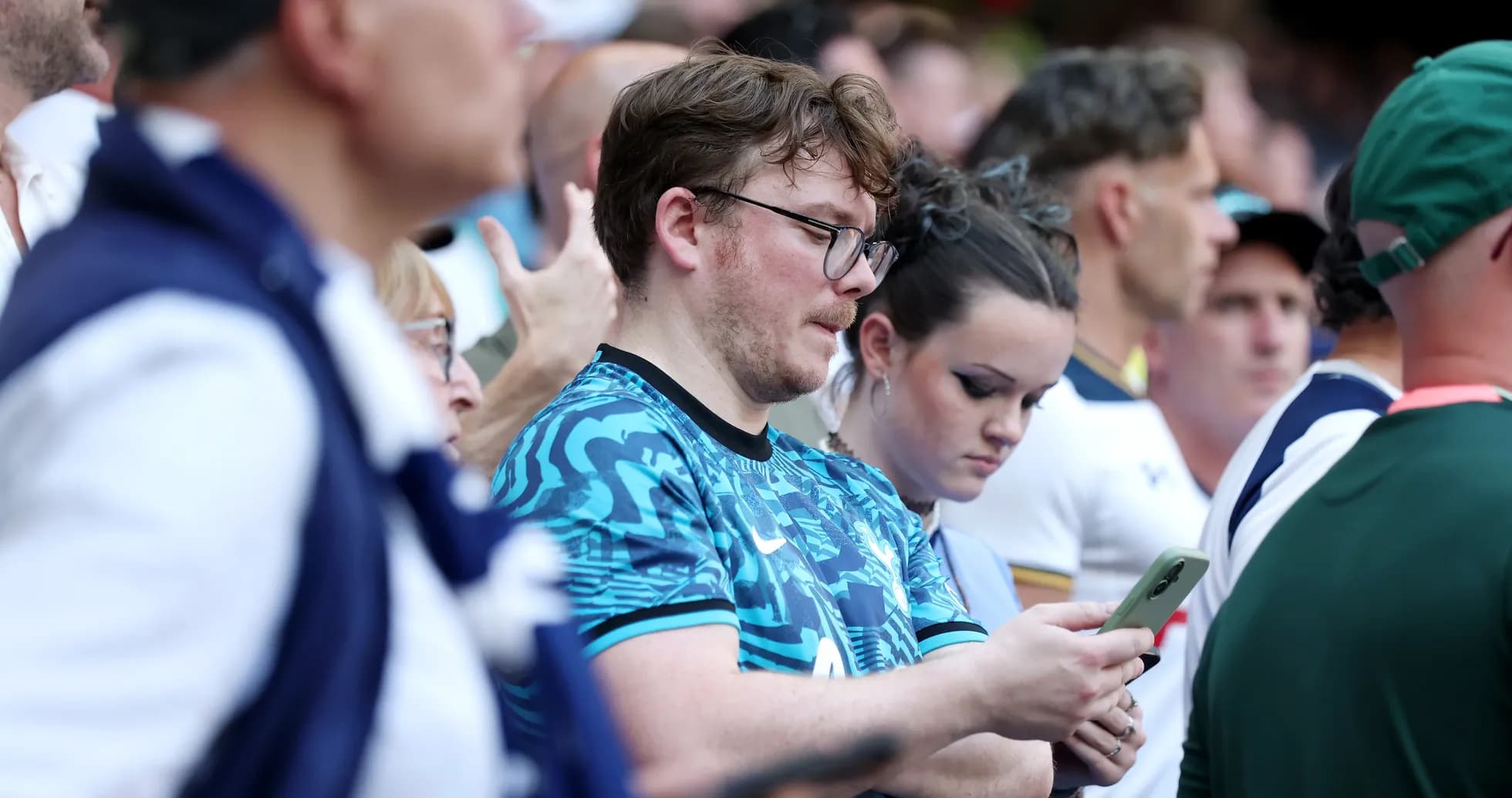 Aficionados revisando sus teléfonos en el estadio Aficionados revisando sus teléfonos en el estadio
