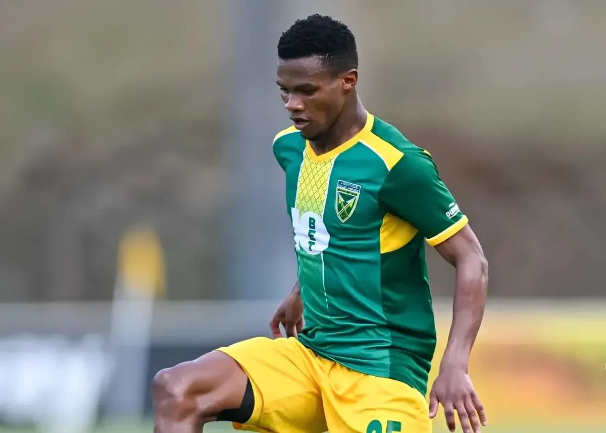 Jugador de fútbol en acción con uniforme verde y amarillo Jugador de fútbol en acción con uniforme verde y amarillo