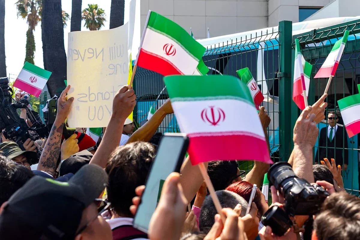 Multitud con banderas de Irán y pancarta en protesta Multitud con banderas de Irán y pancarta en protesta