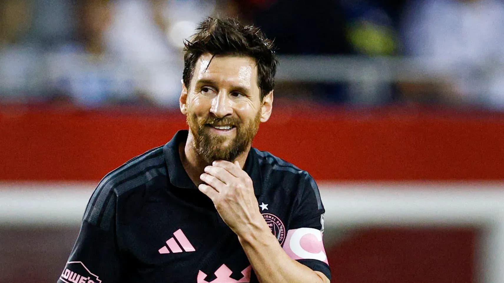 Jugador con camiseta oscura sonriendo en el campo Jugador con camiseta oscura sonriendo en el campo