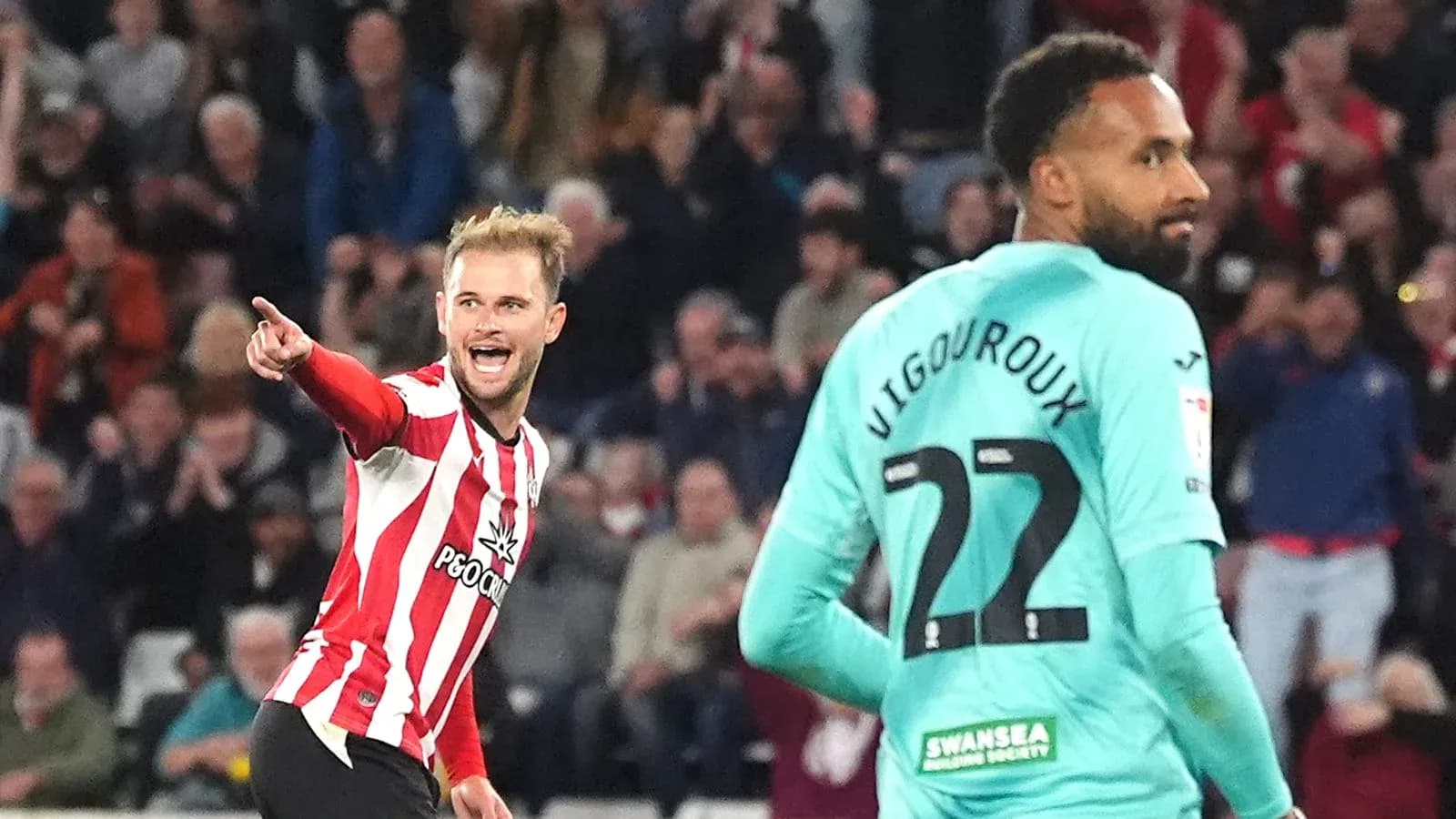 Jugador señalando tras anotar gol, portero en fondo Jugador señalando tras anotar gol, portero en fondo