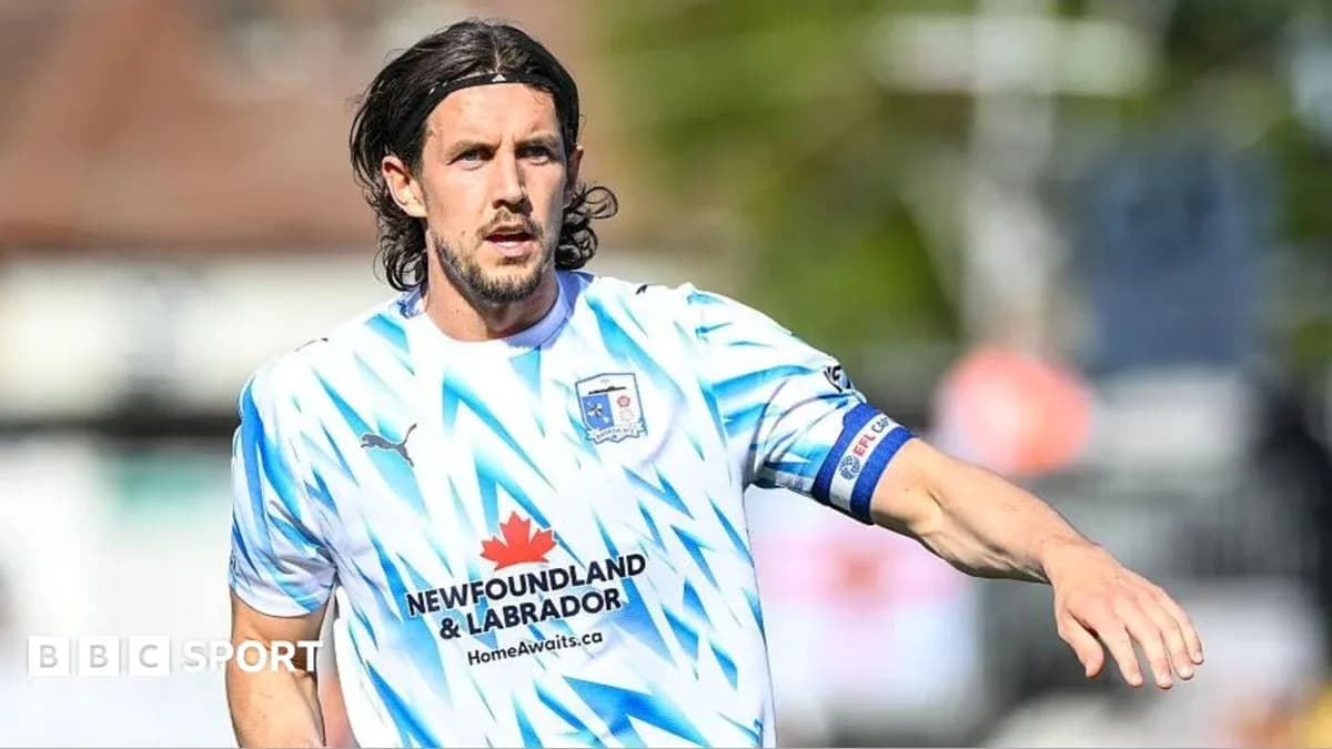 Jugador corriendo en camiseta de fútbol blanca y azul Jugador corriendo en camiseta de fútbol blanca y azul