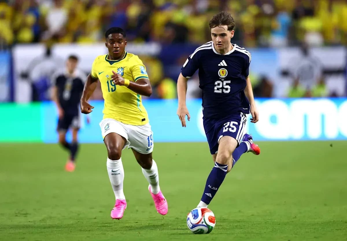 Jugador de Escocia corriendo con el balón, seguido por jugador brasileño Jugador de Escocia corriendo con el balón, seguido por jugador brasileño