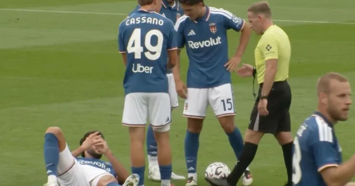 Jugador caído en el campo, árbitro y compañeros presentes Jugador caído en el campo, árbitro y compañeros presentes