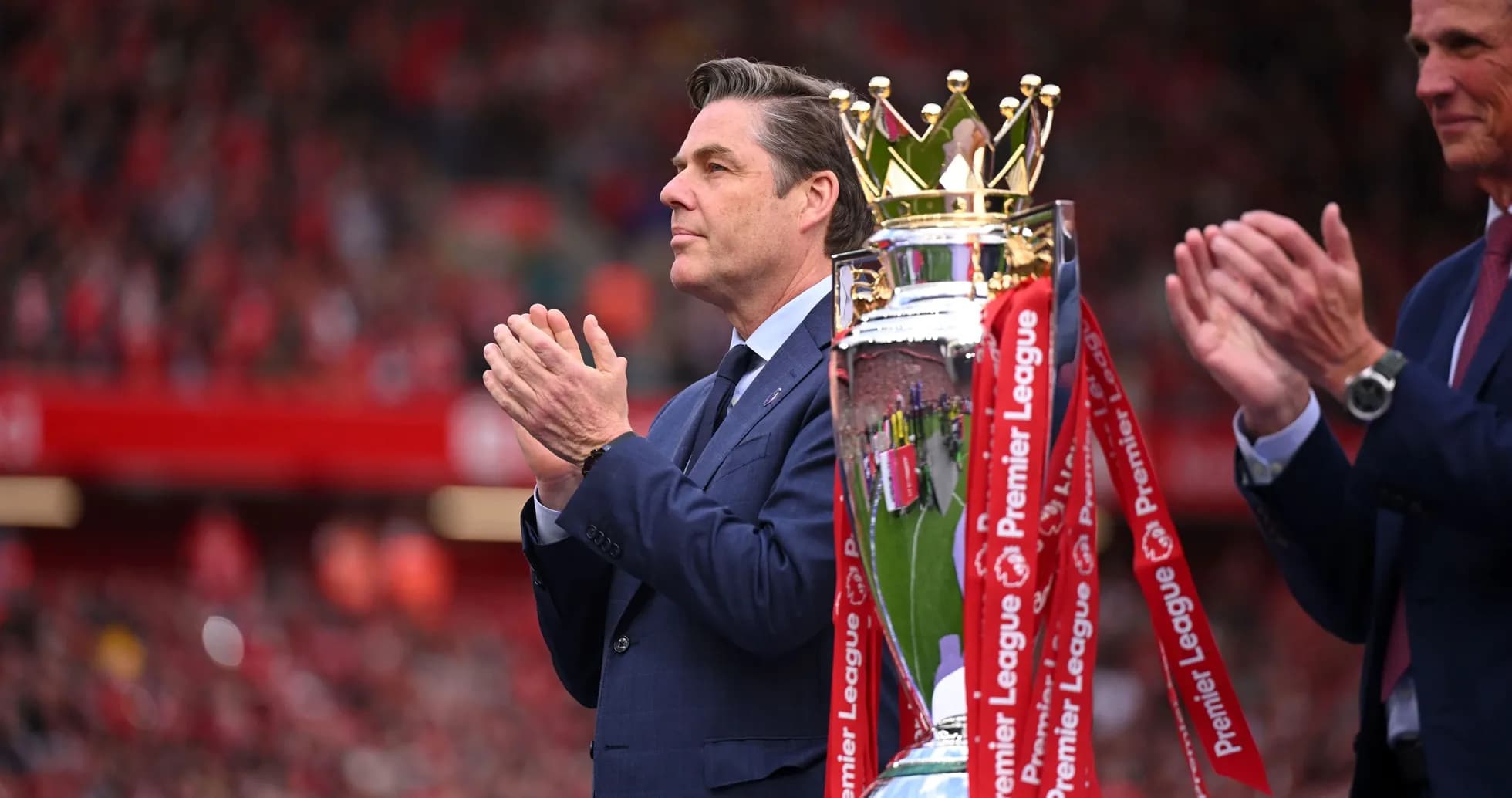 Hombre aplaudiendo junto a trofeo de Premier League Hombre aplaudiendo junto a trofeo de Premier League