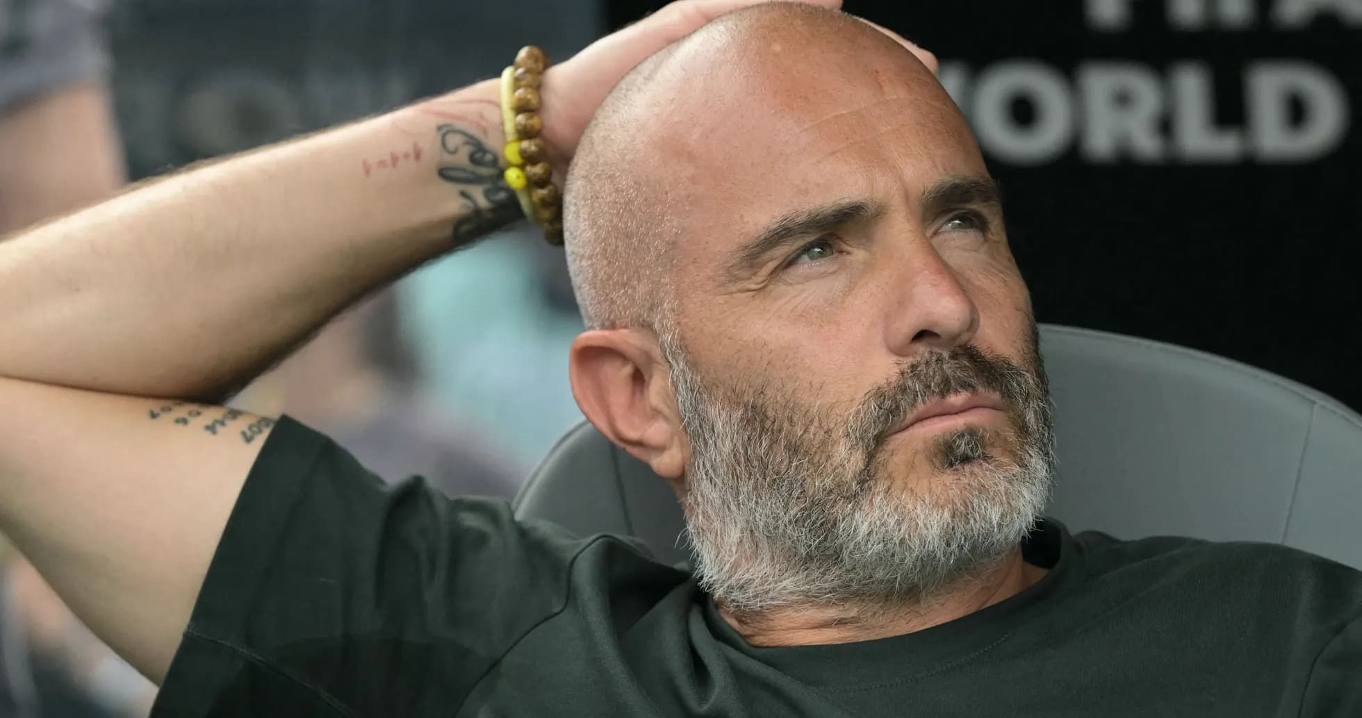 Entrenador sentado en banco durante partido Entrenador sentado en banco durante partido