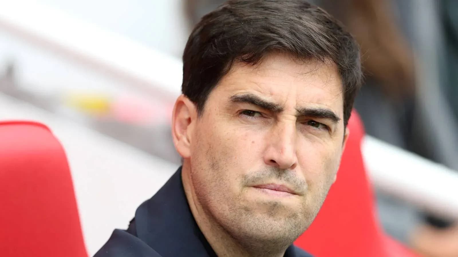 Entrenador observando el partido desde el banquillo Entrenador observando el partido desde el banquillo