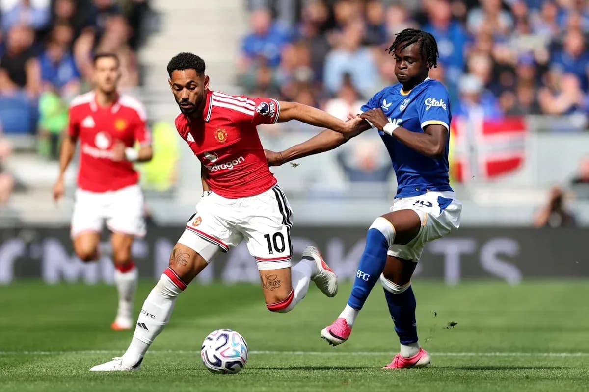 Jugador de Manchester United driblando a rival de Everton Jugador de Manchester United driblando a rival de Everton