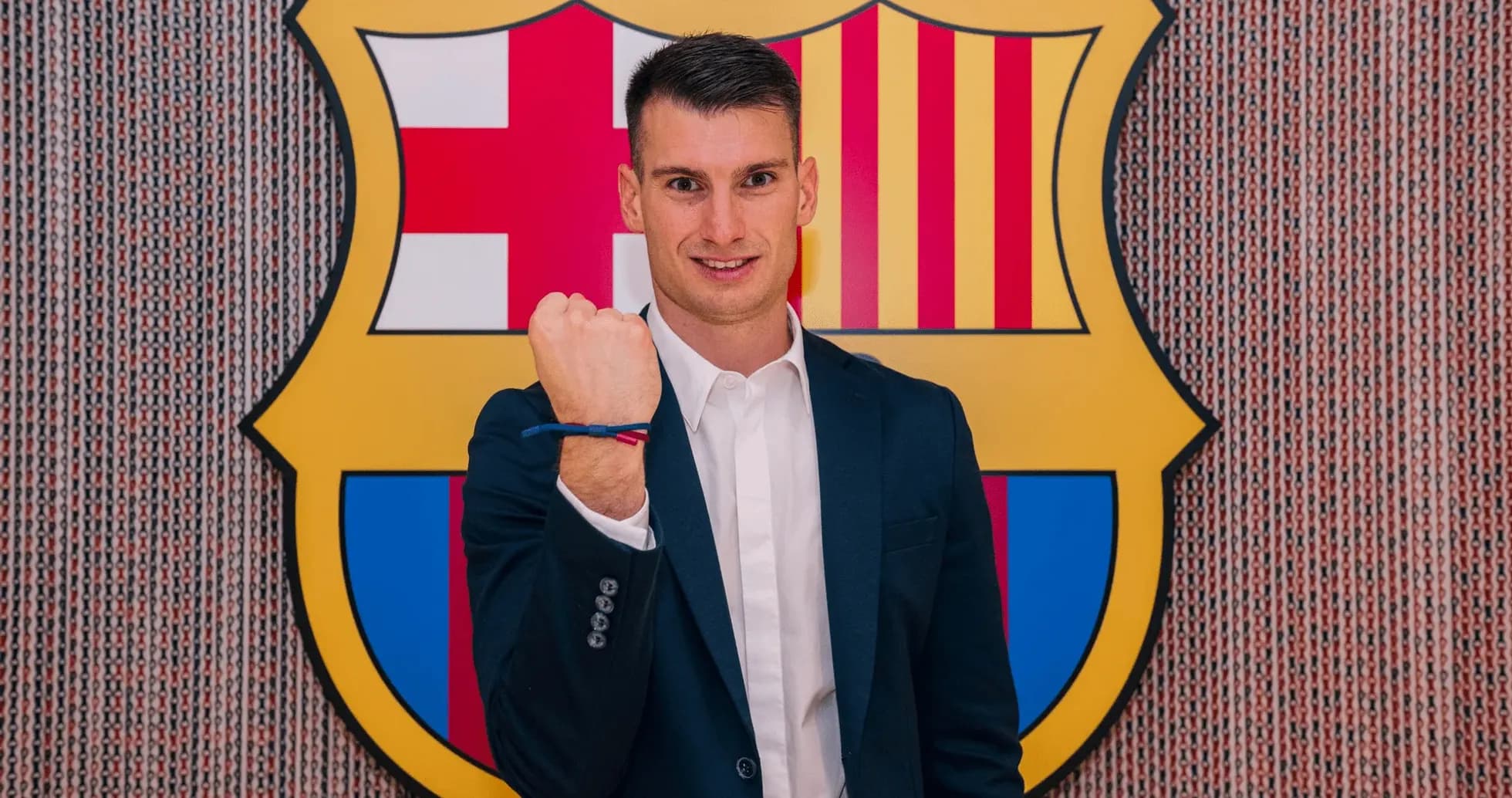 Jugador mostrando su puño frente al escudo del Barcelona Jugador mostrando su puño frente al escudo del Barcelona
