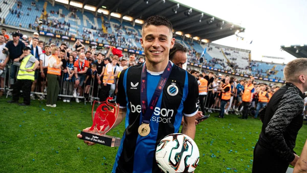 Jugador sosteniendo trofeo y balón en el campo Jugador sosteniendo trofeo y balón en el campo